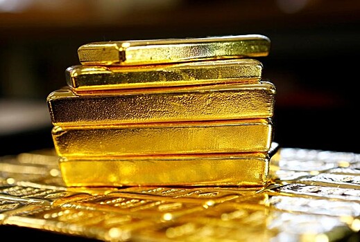 Золото слабо дешевеет на укреплении доллара
