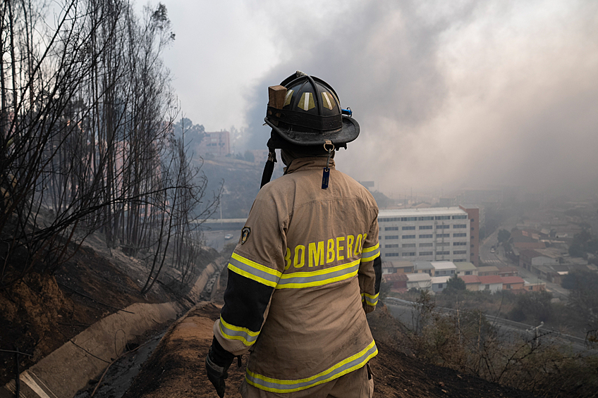 Пожарный на фоне лесных пожаров в районе канала Бигл, Винья-дель-Мар