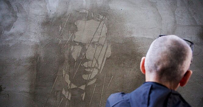 Уличный художник изобразил на стене репрессированных деятелей культуры, портреты которых проступают от воды