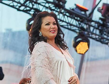 Анна Нетребко в нюдовом платье свободного кроя и льняном кардигане прогулялась по набережной