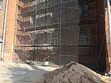 В Академическом районе идут работы по капремонту фасада дома на улице Кржижановского