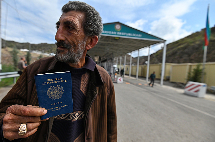 Мужчина показывает паспорт на контрольно-пропускном пункте "Лачин" на въезде в Лачинский коридор, сентябрь 2023 года