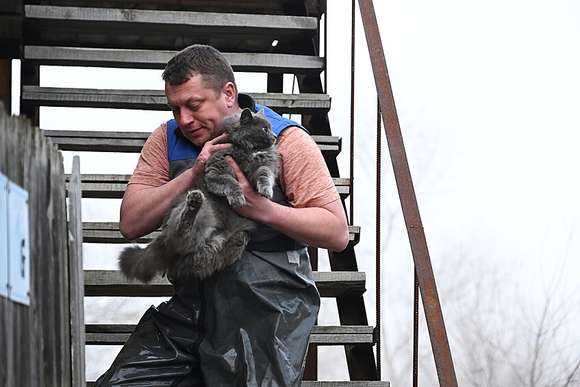 Мужчина эвакуирует кошку из затопленного дома в микрорайоне Форштадт в Оренбурге, 10 апреля 2024 года