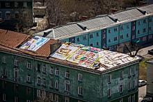 Крышу пятиэтажки на Котовского накрыли баннерами с рекламой шпикачек и кофе