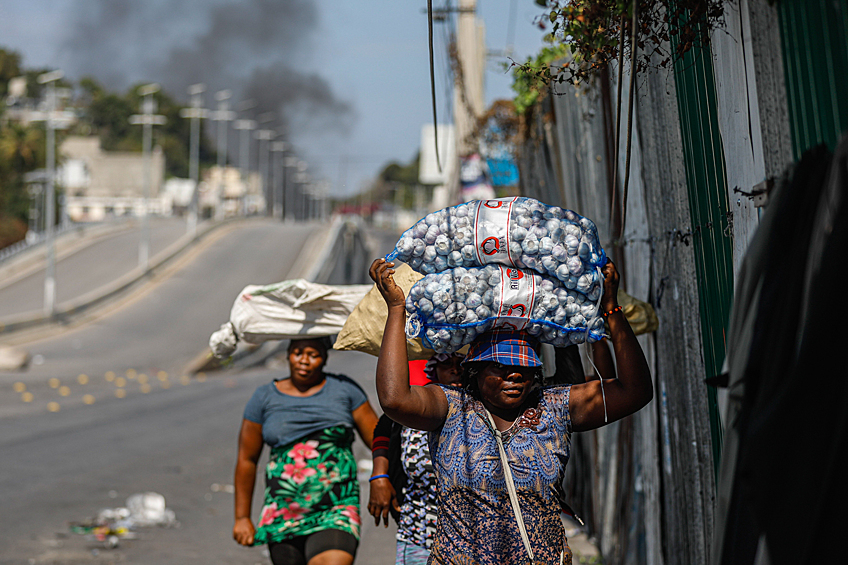 Уличные торговцы бегут от насилия во время столкновений между полицией и бандами в Порт-о-Пренсе