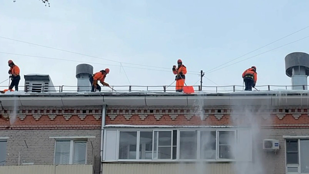 Столичные специалисты проводят очистку крыш жилых домов после снегопада