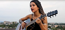 Красивая грузинка играет на гитаре и поет