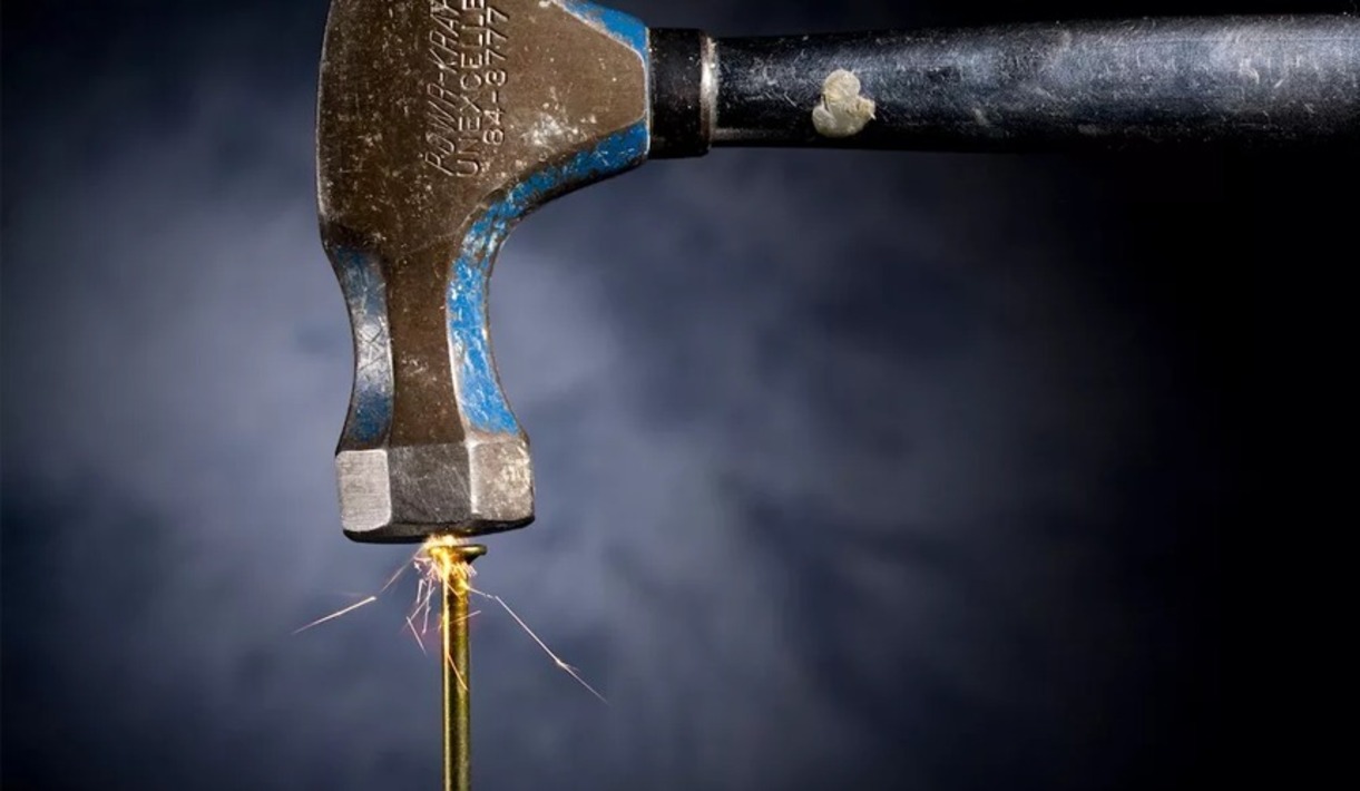 удар молотка по гвоздю. мужик с молотком. молотком вбивают гвоздь. забивает гвоздь.