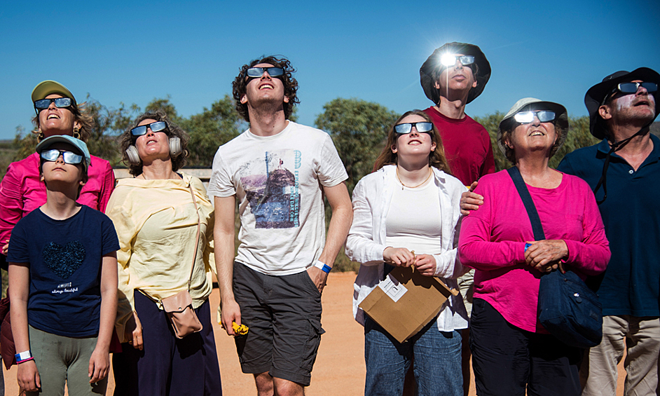 Люди наблюдают гибридное солнечное затмение в Австралии