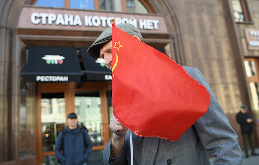 Прохожий с советским флагом у ресторана «Страна, которой нет», 3 сентября 2022 года