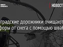 Ленинградские дорожники очищают светофоры от снега с помощью швабр