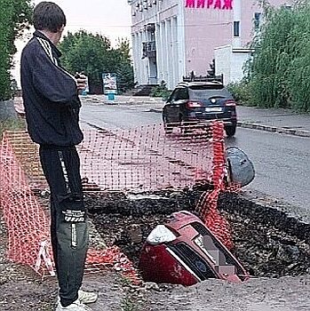 В Саратове автомобиль смыло ливнем в провалившийся асфальт