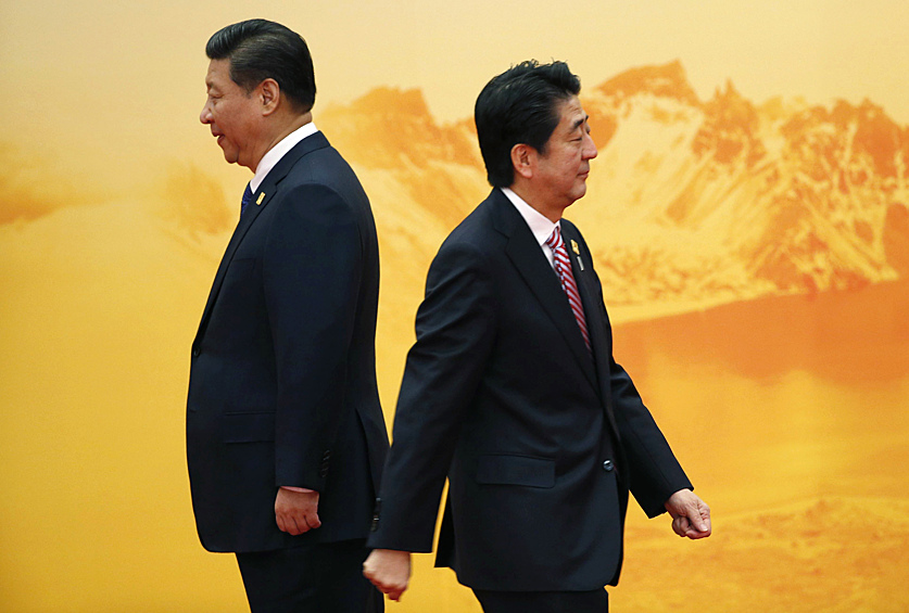 Бывший премьер-министр Японии Синдзо Абэ проходит мимо президента Китая Си Цзиньпина во время приветственной церемонии форума Азиатско-Тихоокеанского экономического сотрудничества, 2014 год