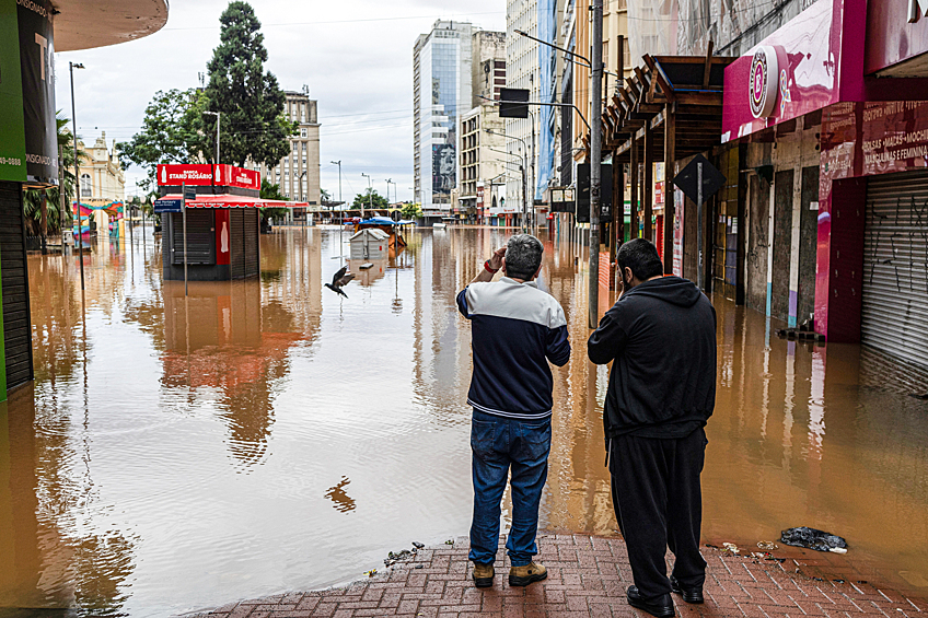 Двое мужчин смотрят на затопленную территорию в городе Порту-Алегри