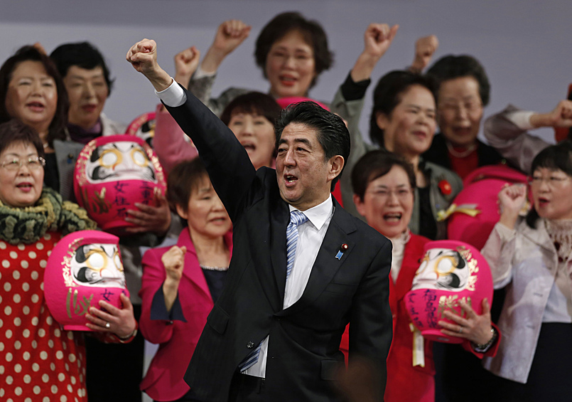 Бывший премьер-министр Японии Синдзо Абэ вместе с членами правящей Либерально-демократической партии (ЛДП), держащими куклы Дарума, которые, как считается, приносят удачу, во время ежегодного партийного съезда в Токио, 2015 год