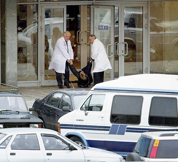 Террористы потребовали вывода российских войск из Чечни. На фото: врачи выносят женщину, которую расстреляли террористы 
