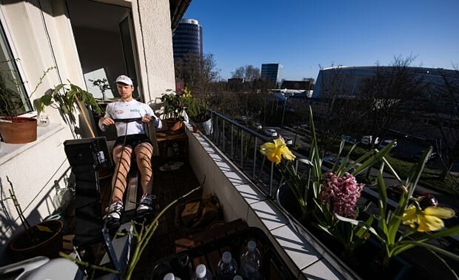 Йоханнес Вайссенфельд, член немецкой гребной восьмерки, тренируется на балконе своей квартиры в Дортмунде.