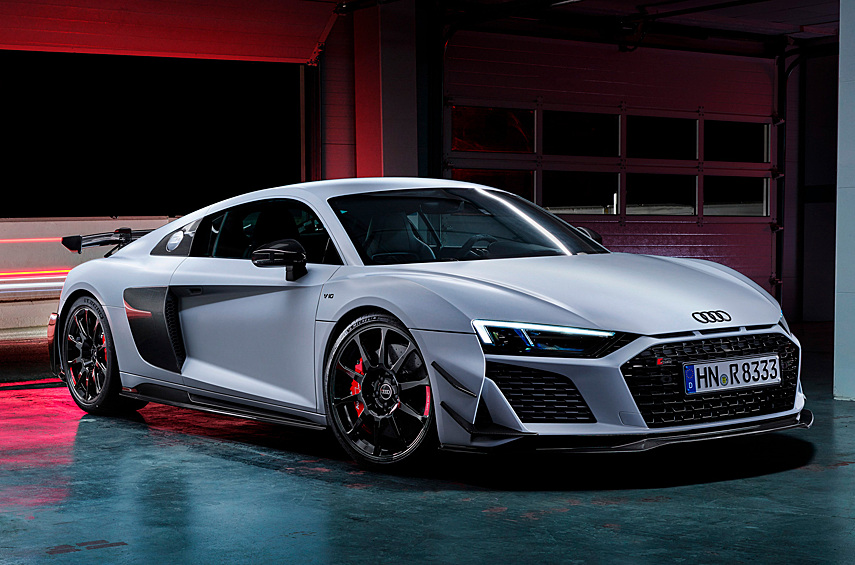 Audi R8 Coupe V10 GT RWD. Ближайший родственник Lambo выглядит восхитительным артефактом на фоне окончательно повернутой на экологичности техники. Увы, в следующем поколении яростная «эрка», вероятно, пойдет тропой электрификации. Прошлогоднему V10 GT RWD выпала честь стать прощальным исполнением. По сути это гибрид заднеприводного шасси и 620-сильного двигателя объемом 5,2 литра от полноприводного R8. Напомним, раньше машины с задними ведущими колесами не могли мечтать об агрегатах мощнее 570 л.с.