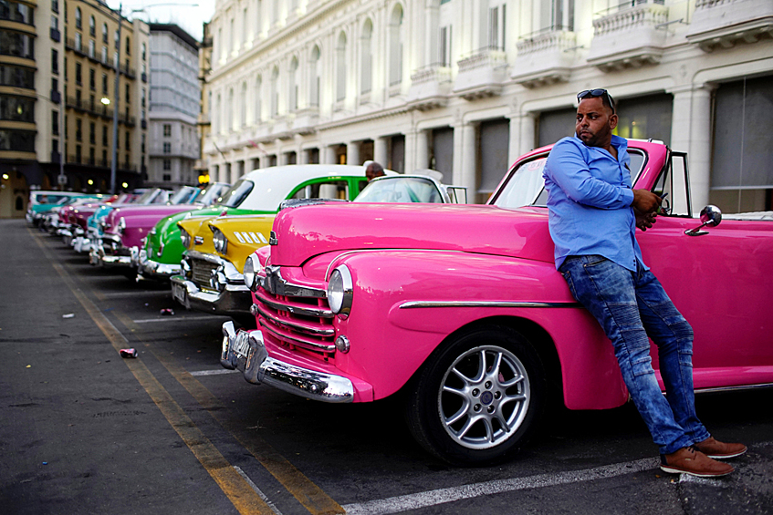 Таксист Джовани Бернати ждет туристов у парковки раритетных автомобилей в Гаване