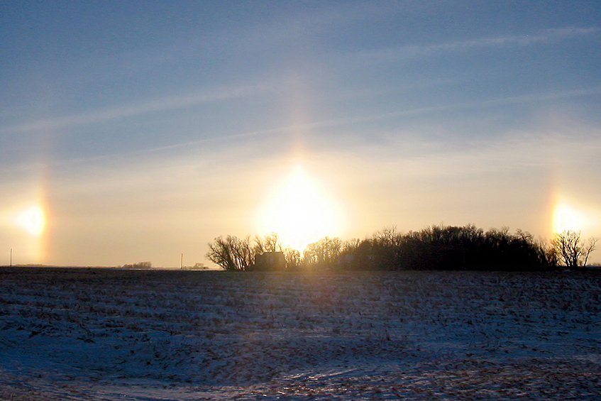 Паргелий. При этом редком погодном явлении на небе можно увидеть сразу три “солнца”. Появляются они только зимой и лишь при ясной погоде: солнечные лучи преломляются кристалликами льда в воздухе, создавая справа и слева от настоящего солнца его “двойников”.