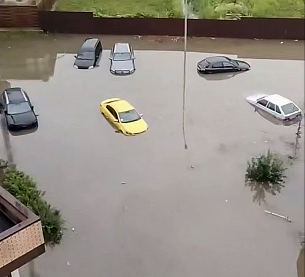Затопленные автомобили на парковке у жилого дома
