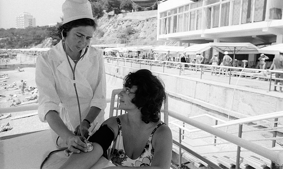 Медсестра лечебного пляжа санатория в Крыму А. Г. Мельникова проверяет состояние здоровья отдыхающей из Кабардино-Балкарии, 1977 год