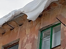 Омичи сообщили о снежных глыбах, опасно свисающих с крыши дома в Нефтяниках