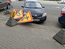 Дорожный знак рухнул на припаркованный автомобиль на площади Свободы (ФОТО)