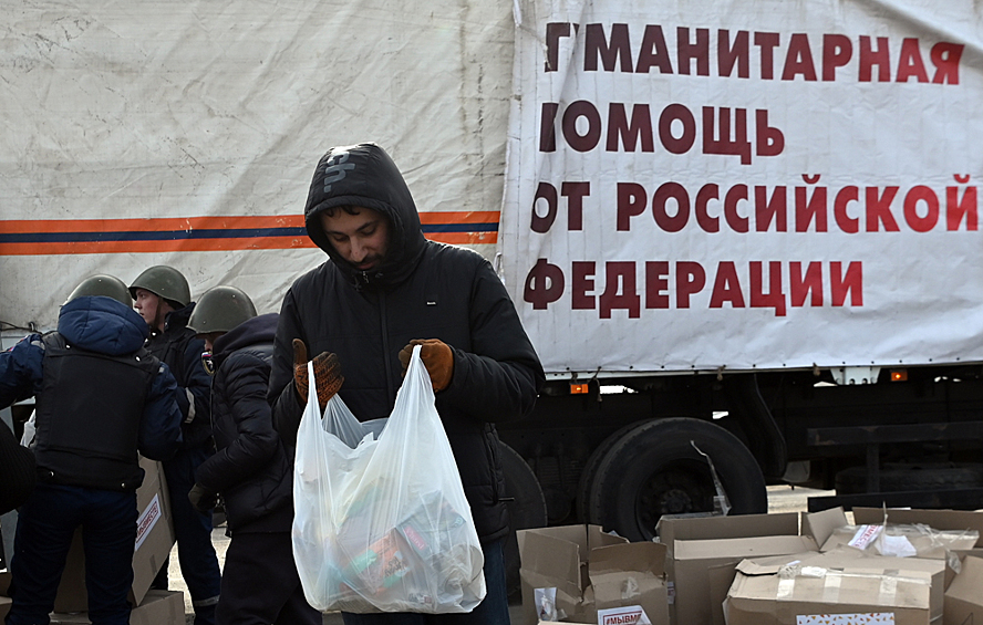 Житель Мариуполя получает у бойцов Народной милиции ДНР гуманитарную помощь, доставленную из России