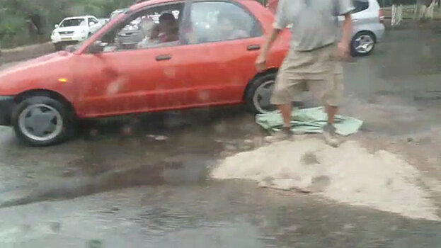 Водитель остановился, чтобы засыпать песком яму в Бишкеке, — видео