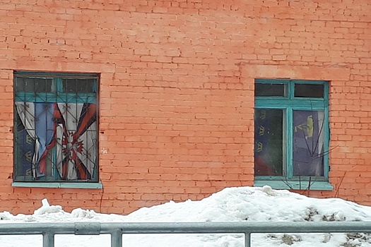 Окна двухэтажного здания, которое принадлежит администрации, завесили флагами России и Тюменской области