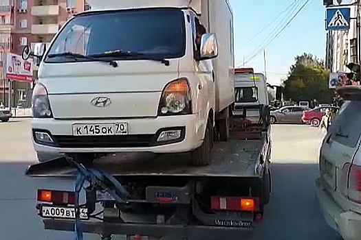 Видео: эвакуатор увёз из центра Новосибирска машину с водителем за рулём
