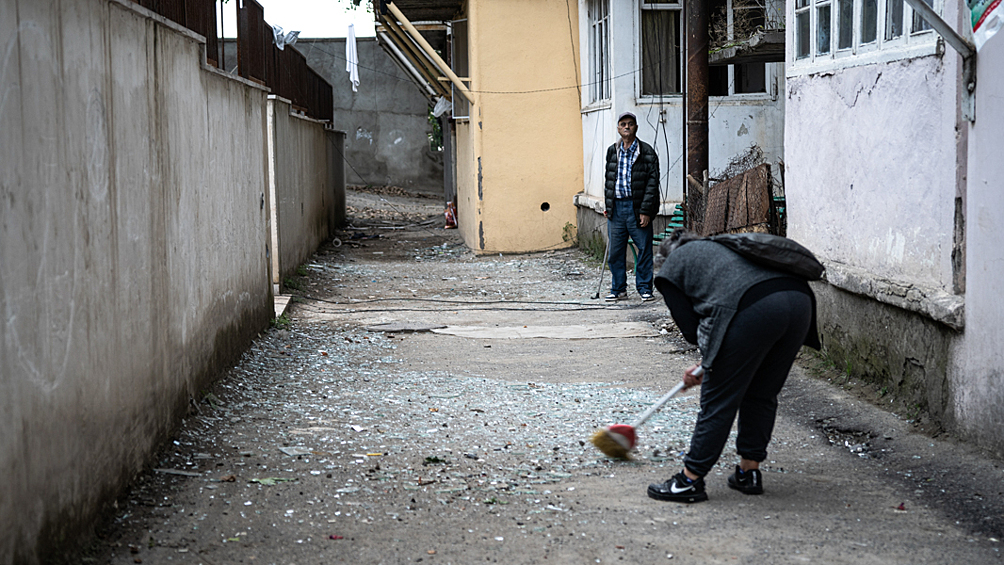 Жители во дворе жилого дома, пострадавшего в результате обстрела в Степанакерте