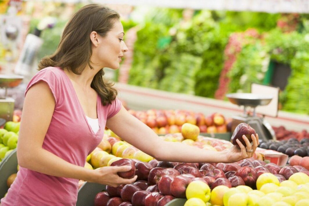Есть 75 яблок выберите все верные. Женщина выбирает овощи в магазине. Женщина на рынке выбирает овощи. Женщина выбирает фрукты в магазине. Девушка выбирает овощи.