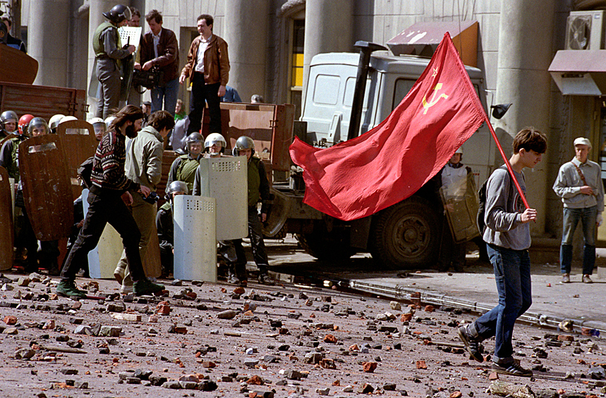 Одинокий демонстрант-коммунист, идущий по усыпанной камнями улице после кровопролитного столкновения с правоохранительными органами, 1993 год.