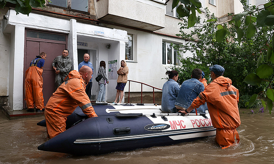 Сотрудники МЧС РФ во время эвакуации местных жителей на подтопленной улице