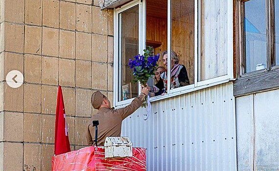 Сергей Миронов поднялся на автовышке и через окно вручил букет ветерану труда