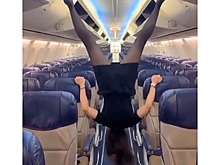 Стюардесса закрыла багажные полки раздвинутыми ногами