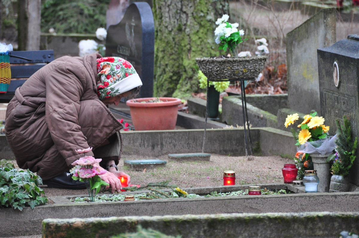 Родительская суббота на кладбище. Свечка на кладбище. Пожилая женщина на кладбище. Свечи на могиле на кладбище.