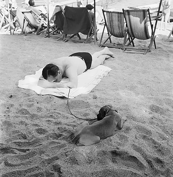 Август 1952 года. Мужчина с собакой на пляже Параджи недалеко от итальянского туристического городка Портофино.