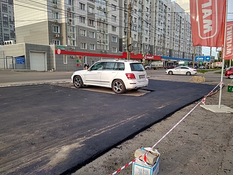 Укладку асфальта вокруг машины сфотографировали в Воронеже