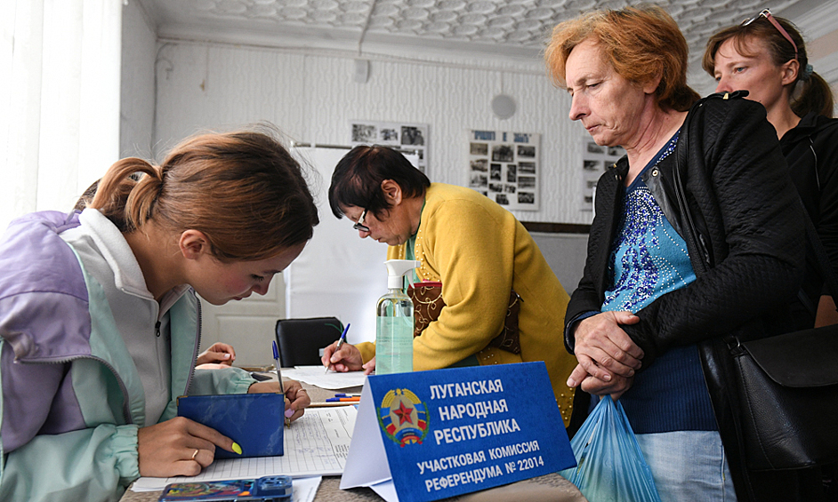 Люди регистрируются на избирательном участке в Белогорске для участия в голосовании на референдуме о присоединении ЛНР к России