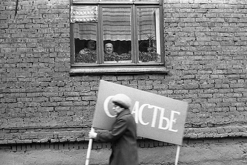 «Счастье, проходящее мимо», Новокузнецк, 1 мая 1983 года. Эти фото — шедевры, потому что они не про эффекты, а про жизнь.Вот, например, «Счастье, проходящее мимо» — рядовая ситуация на демонстрации оборачивается целой притчей. И чисто технически эта притча передана ясно и четко, тут нет ничего лишнего, все работает на одну идею.