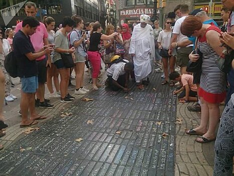 Фотофакт: туристы на улице Рамбла выражают поддержку Испании