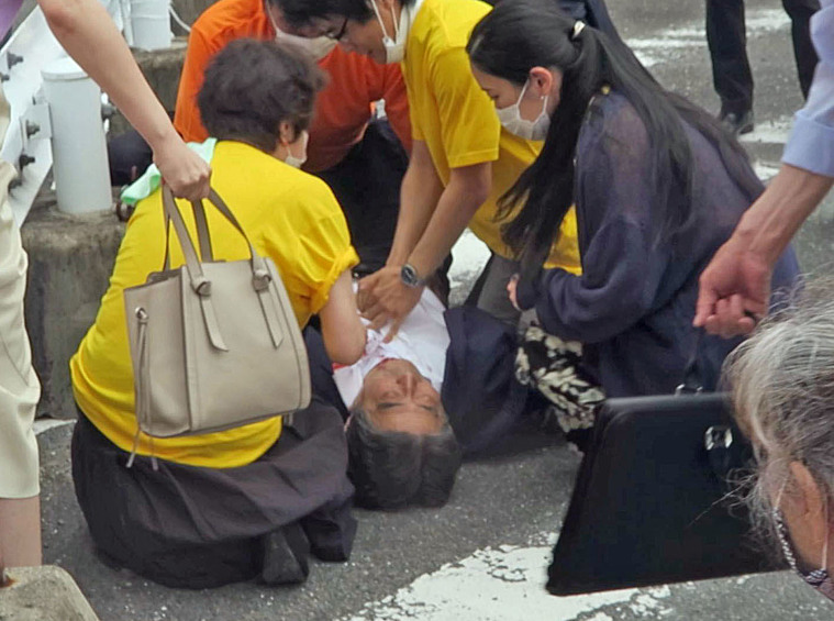 Бывший премьер-министр Японии Синдзо Абэ лежит на земле после покушения, 8 июля 2022 года