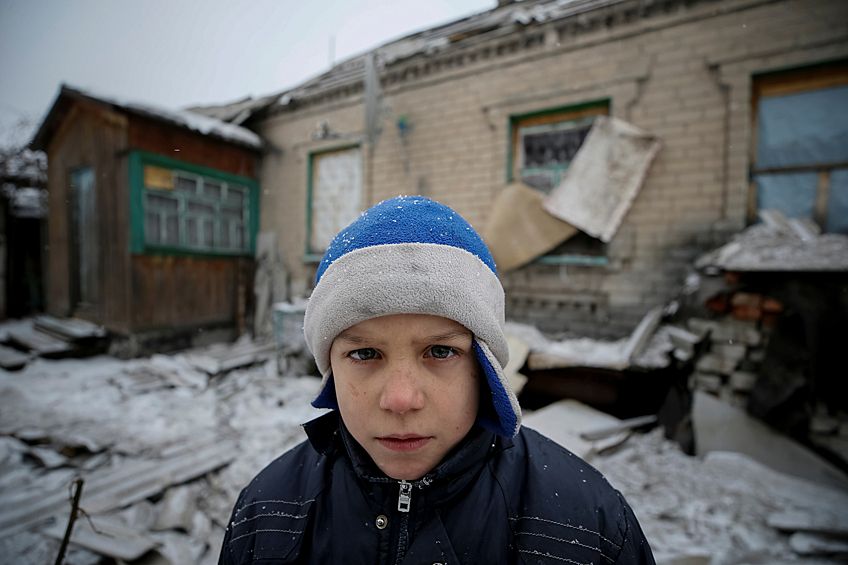 Восьмилетний Леша у своего разрушенного дома