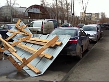 На стройке ЖК «Флагман» часть забора снесло ветром на три машины