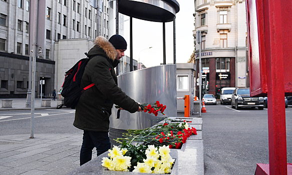 Люди несут цветы к месту перестрелки на Лубянке