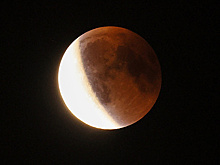 Красная луна над облаками: в РФ наблюдалось первое за семь лет полное лунное затмение