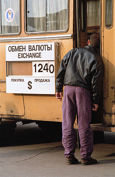 В СССР свободный оборот валюты был фактически под запретом. В начале 90-х россияне узнали о курсе доллара и как за одну ночь можно потерять все сбережения. Передвижной пункт обмена валюты у ресторана "Прага", 1993 год